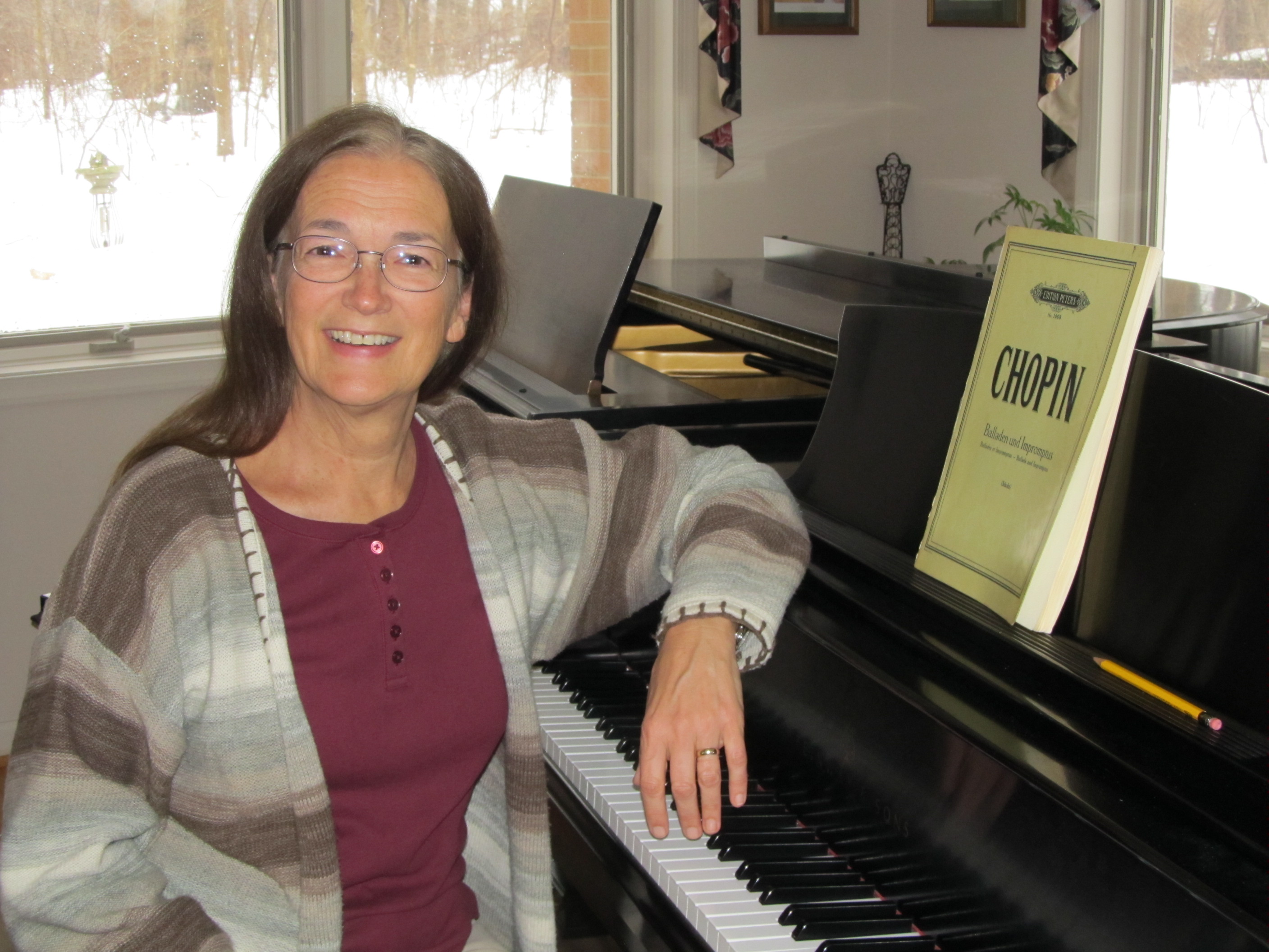 Donna sits at a piano in the studio